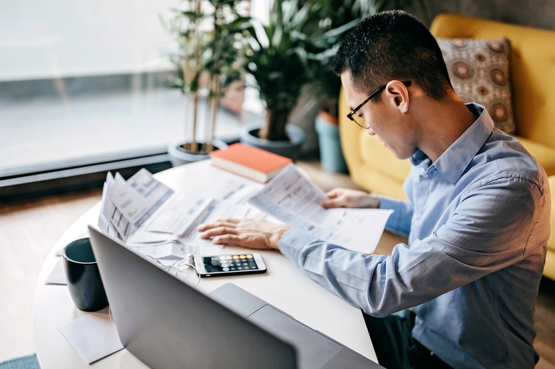 a man sitting at a table using a laptop